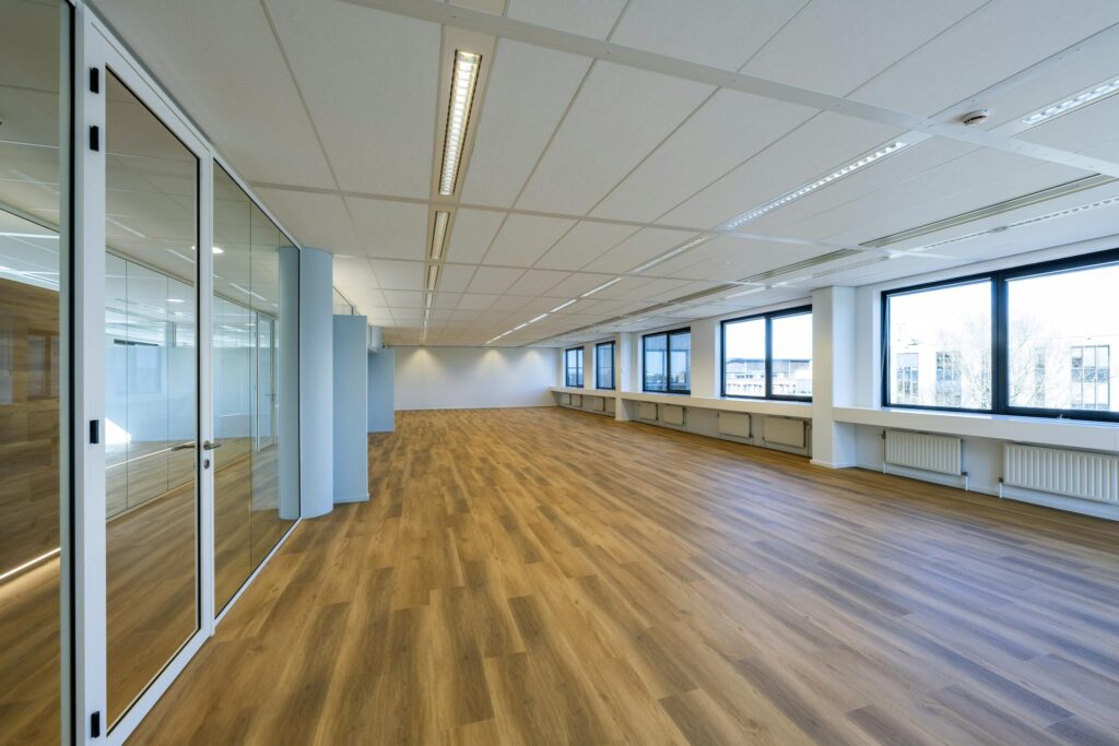 Bright, modern office space on Prof. W.H. Keesomlaan with large windows, glass partitions, and wood-look flooring.